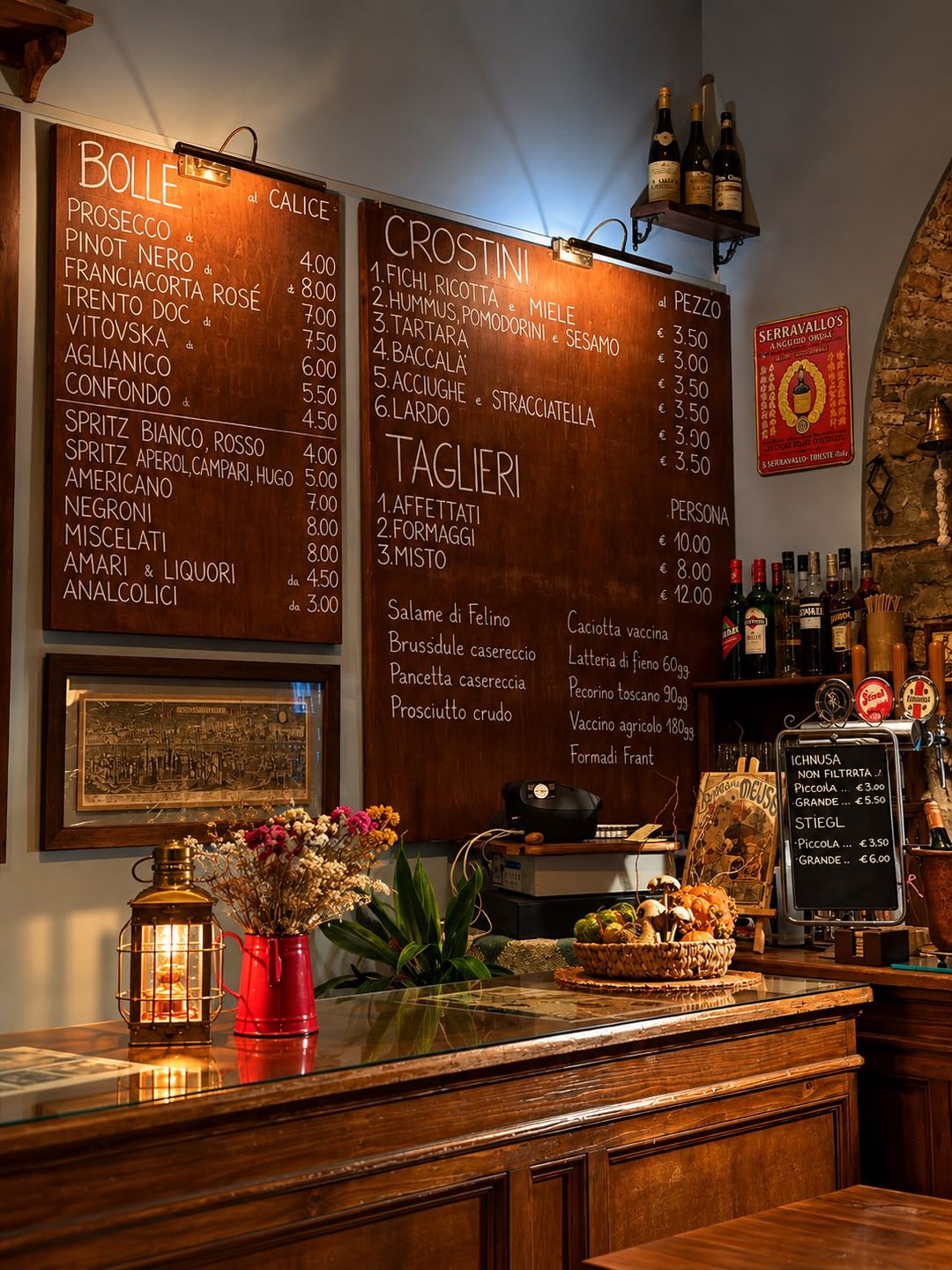 Il bancone di Trebisonda con il piano in vetro, una lanterna d'ottone accesa e fiori secchi in una brocca rossa; dietro, le lavagne di bolle, crostini e taglieri e le spine della birra. Foto ritoccata con l'intelligenza artificiale.